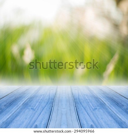 Perspective blue wood over blur trees with bokeh background - can be used for display or montage your products, spring and summer season