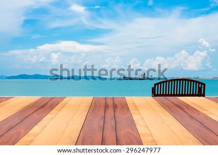 Vintage wooden board empty table in front of summer landscape. Perspective wood floor over sea with wooden bench - can be used for display or montage your products. Viewpoint out to sea background.