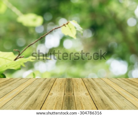 Wooden board empty table in front of blurred background. Perspective yellow wood over blur trees in forest - can be used for display or montage your products. spring season. vintage filtered image.