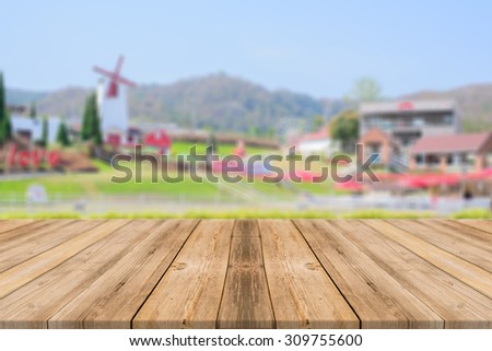 Wooden board empty table in front of blurred background. Perspective brown wood over blur beautiful resort and landscape mountain hill with bokeh - can be used for display or montage your products.