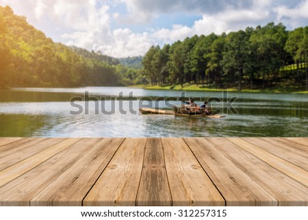 Wooden board empty table in front of blurred background. Perspective grey wood over blur lake in forest - can be used for display or montage your products. spring season. vintage filtered image.
