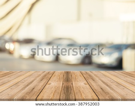 Wooden board empty table blurred background. Perspective brown wood over blur car park outdoor - can be used for display or montage your products. Mock up for display of product. Vintage filter image.