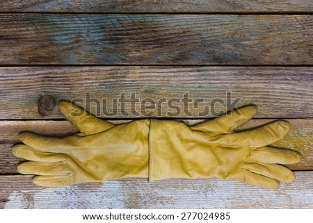 yellow women\'s gloves on the old boards