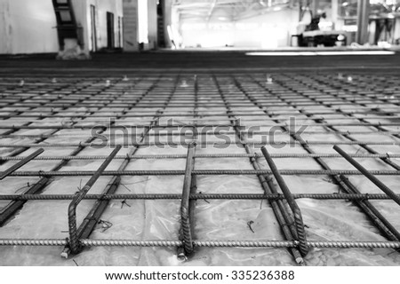 the reinforcing grid fastened with a wire from a channeled steel rod under filling of concrete floors, in black and white