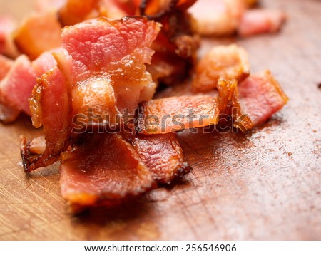 Cooked bacon pieces on wood.