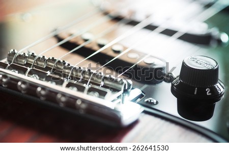 electric guitar closeup of bridge, volume and pickups