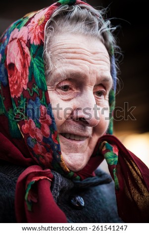 Smiling old woman with red scarf in winter