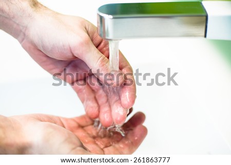 Washing hand under tap water