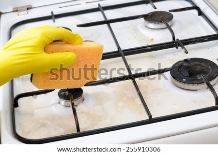 cleaning of dirty gas stove burners in kitchen room