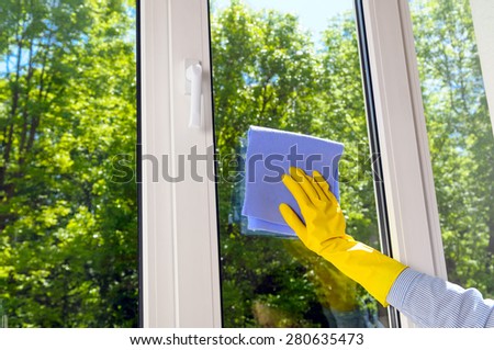 cleaning plastic vinyl window on a background green leaf