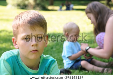 sad boy with brother and mother in garden