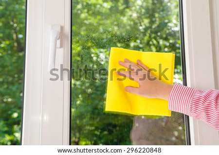cleaning plastic vinyl window on a green leaves background