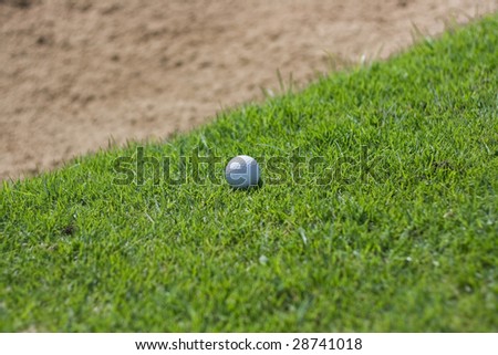 Golf ball that is close to the edge of the sand