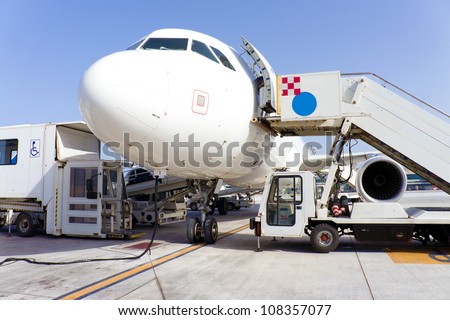Airplane in airport serviced by the ground crew
