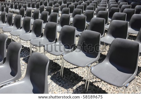 Rows of empty black chairs waiting for the audience