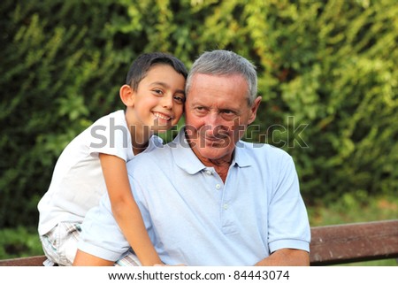 grandson smiling with grandfather in a park