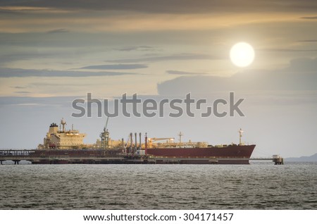 Oil Tanker loading oil in the sea at sunset