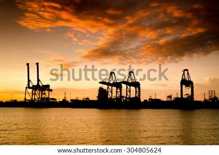 Containers loading by crane in Silhouette , Trade Port , Shipping , transport