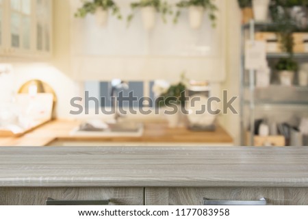 Blurred background. Modern defocused pastel kitchen with empty wooden tabletop and space for you design.