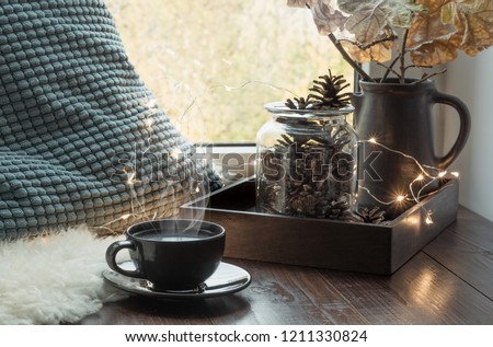 Still life in home interior. Cozy winter or autumn cup of coffee at home warm fluffy furskin , garland, swedish hygge concept.