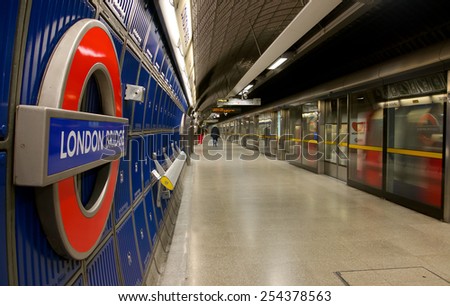 London, UK - February 26, 2014: Picture of the platform of London Bridge Underground station, with a train coming into the station and travelers in the back ground.