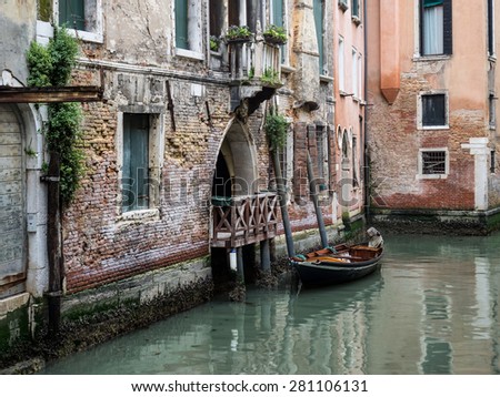 View of a side canal and old buildings in the centre of Venice. Balconies overlooking the canal