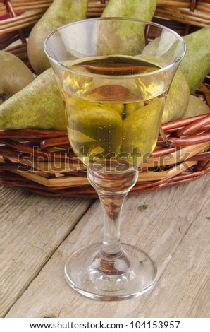 fruit wine in a glass and fresh pears in the background