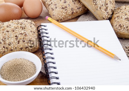 sesame roll and a booklet for notes with a yellow pencil