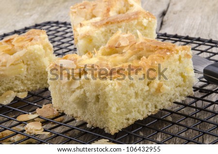 freshly baked apple cake with almond flakes on a baking rack