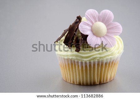cupcake with lemon butter cream, chocolate curls and flower