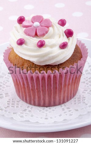 vanilla cupcake with pink flower and red chocolate beans
