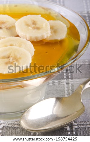 greek natural yogurt with wild flower honey and banana slices in a glass