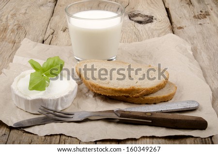 goat cheese, basil,  bread and milk on a country house kitchen table