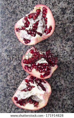 in three parts broken pomegranate on a marble top