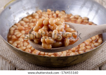 baked beans in a pan and wooden spoon