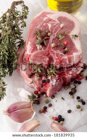raw lamb chops with pepper, sea salt, thyme, garlic and oil