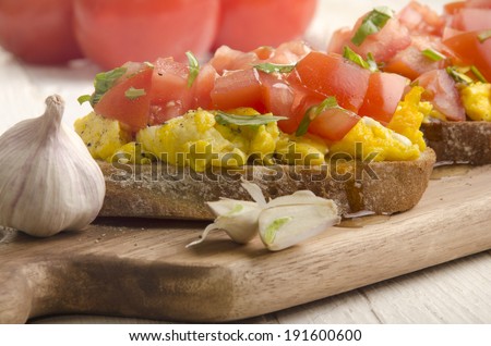 bruchetta with scrambled eggs, tomato, crushed pepper and garlic