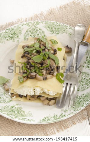 lasagna with mushrooms, cottage cheese and basil on a plate
