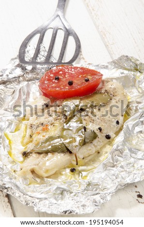 baked pangasius with pepper and tomato in tin foil