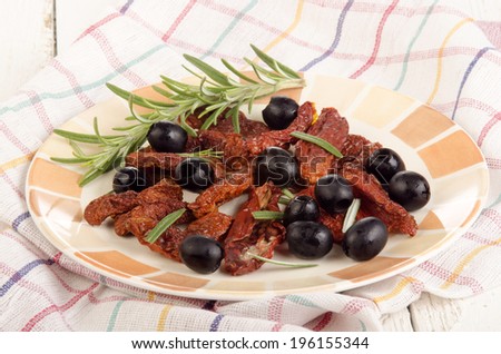 black olive, rosemary and sun dried tomatoes on a plate