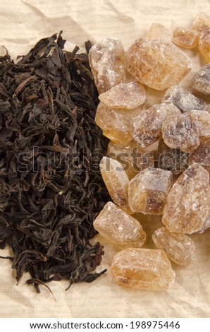 brown rock candy sugar and black tea on brown paper