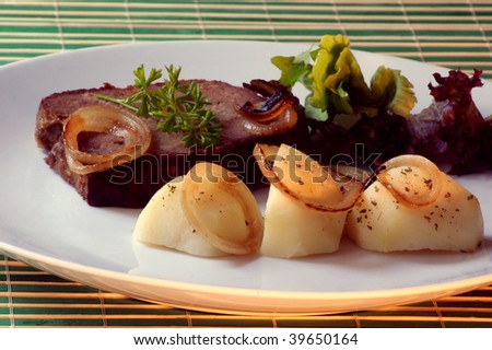 sliced meat loaf with organic potato on a plate