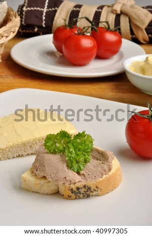 half bread roll with liver sausage on a plate