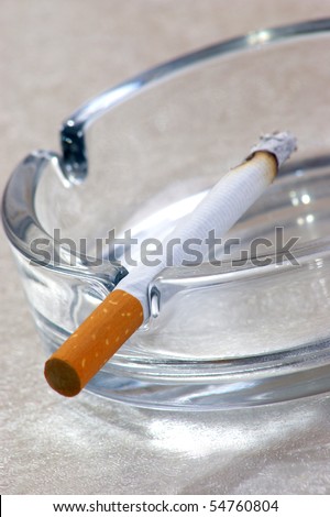 one unhealthy cigarette in a glass ashtray