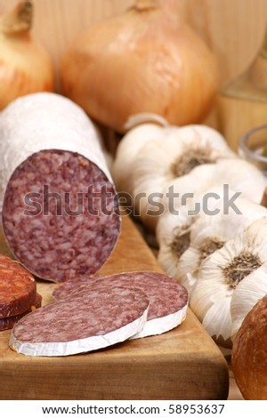salami and some slices salami on a timber board