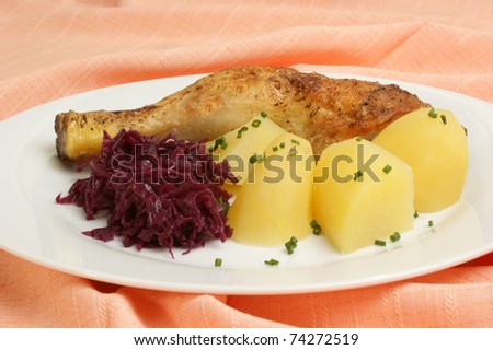 Grilled chicken drumstick with potatoes and red cabbage