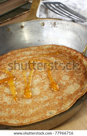 home made pancake with syrup in a brass pan