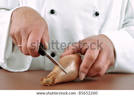 female chef cut an onion with a kitchen knife