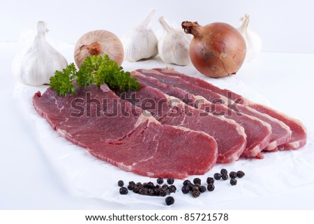 thin cut beef steaks with garlic and onions