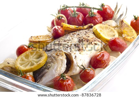 baked sea bass with tomato, garlic and lemon slices